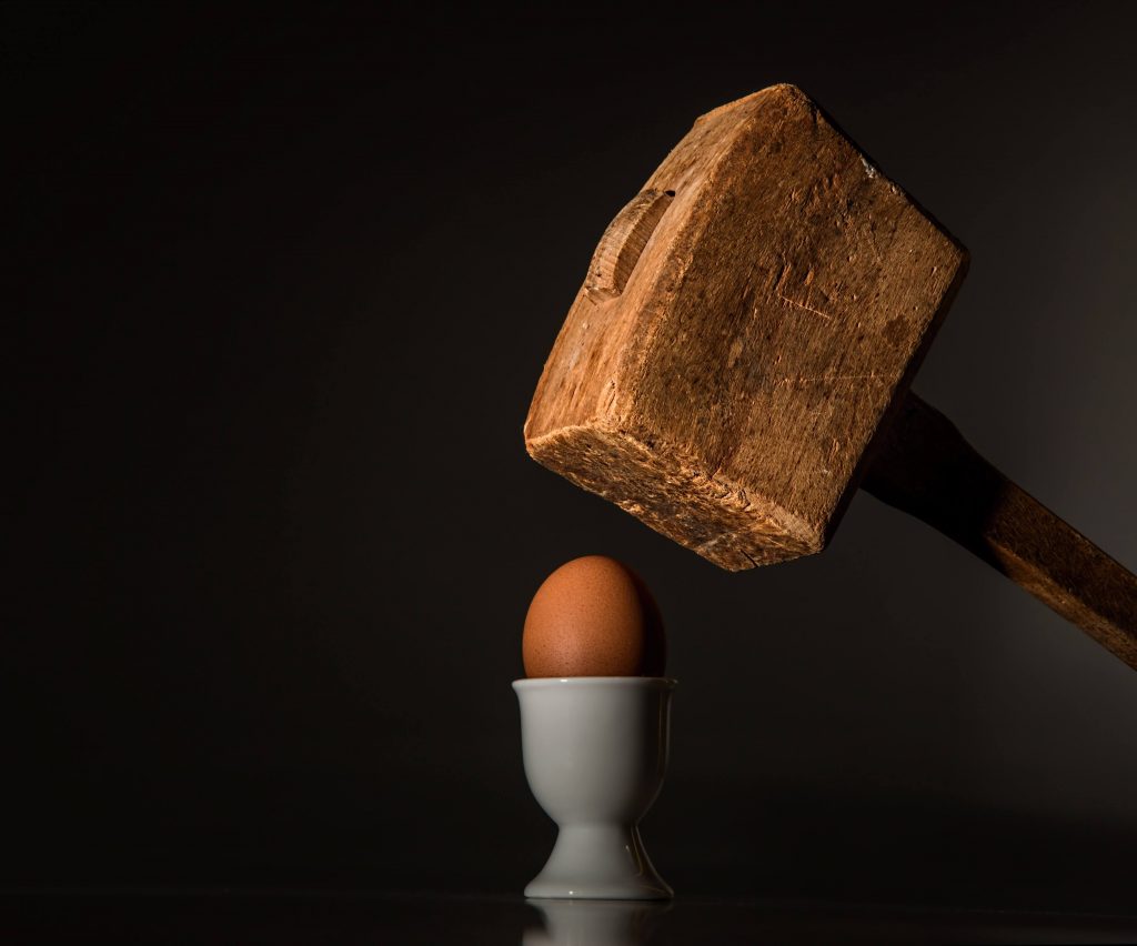 Imagem ilustrando o ditado "para quem só tem martelo, tudo é prego". Uma marreta é usada para quebrar um ovo cozido